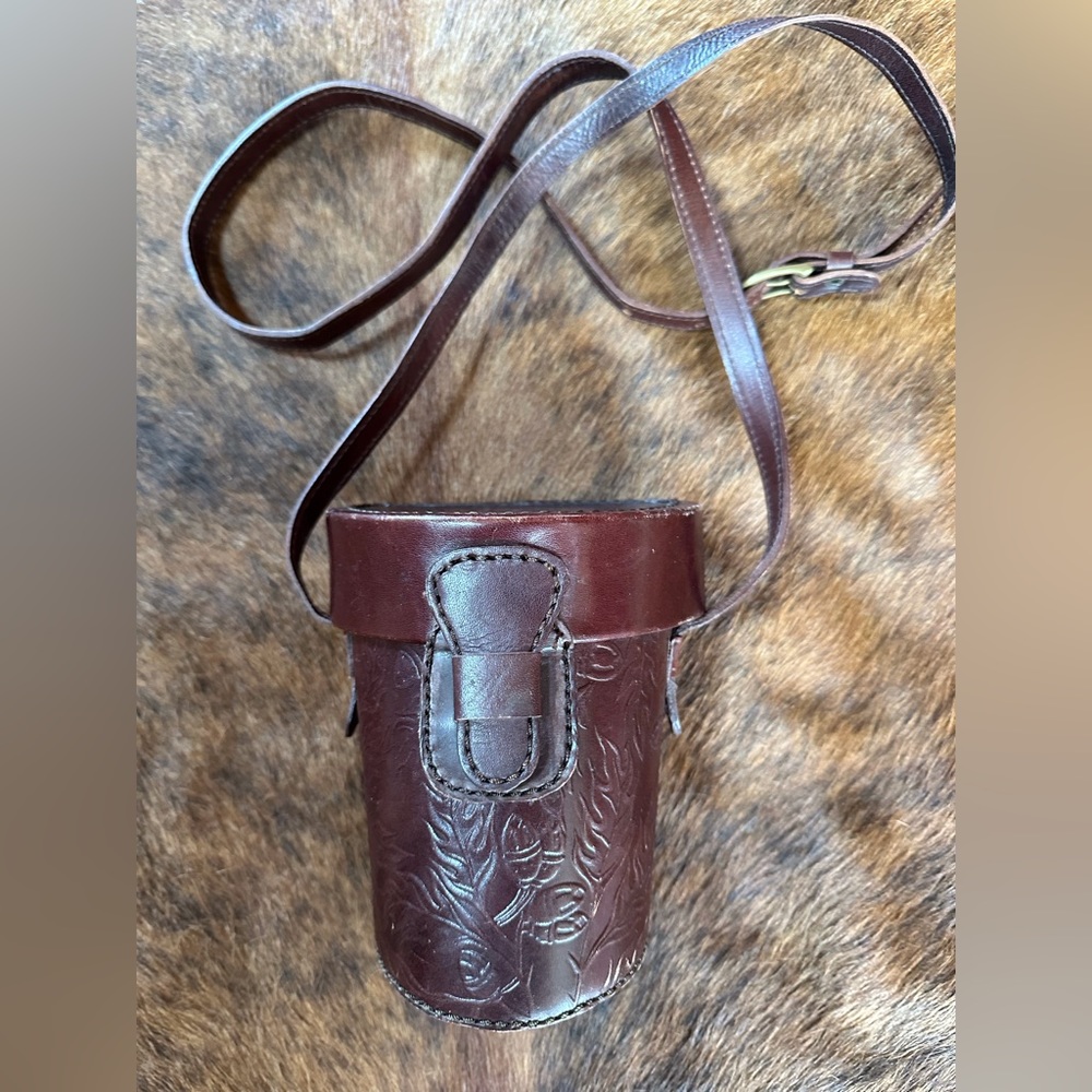 Tooled bag in brown leather. 6” x 5”with fabric liner inside.
